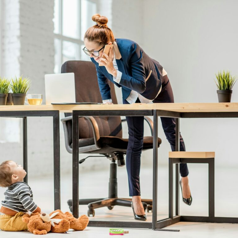 Multitasking businesswoman with her son at the office