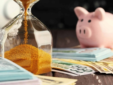 Time and money business concept. Sandglass and money