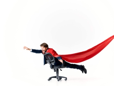 business man in red cloak superman manager office. High quality photo