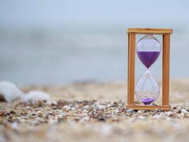 Hourglass at the beach on the ground. High quality photo