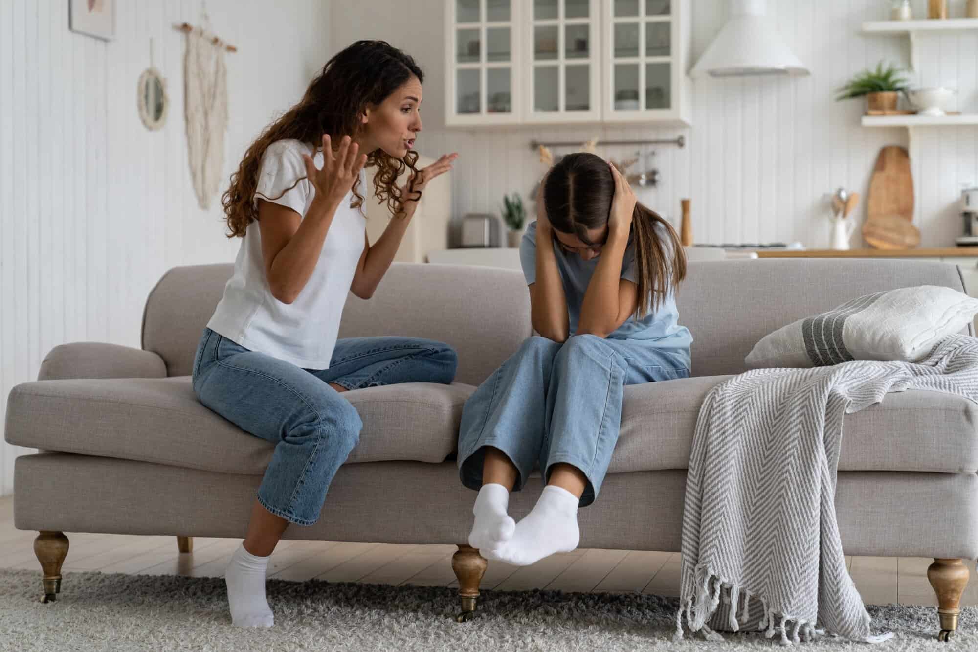 Angry woman mother shouting at teenage daughter trying to discipline child, yelling at kid