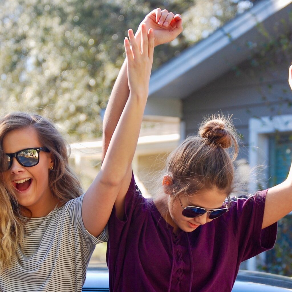 Happy teenage girls dancing outside