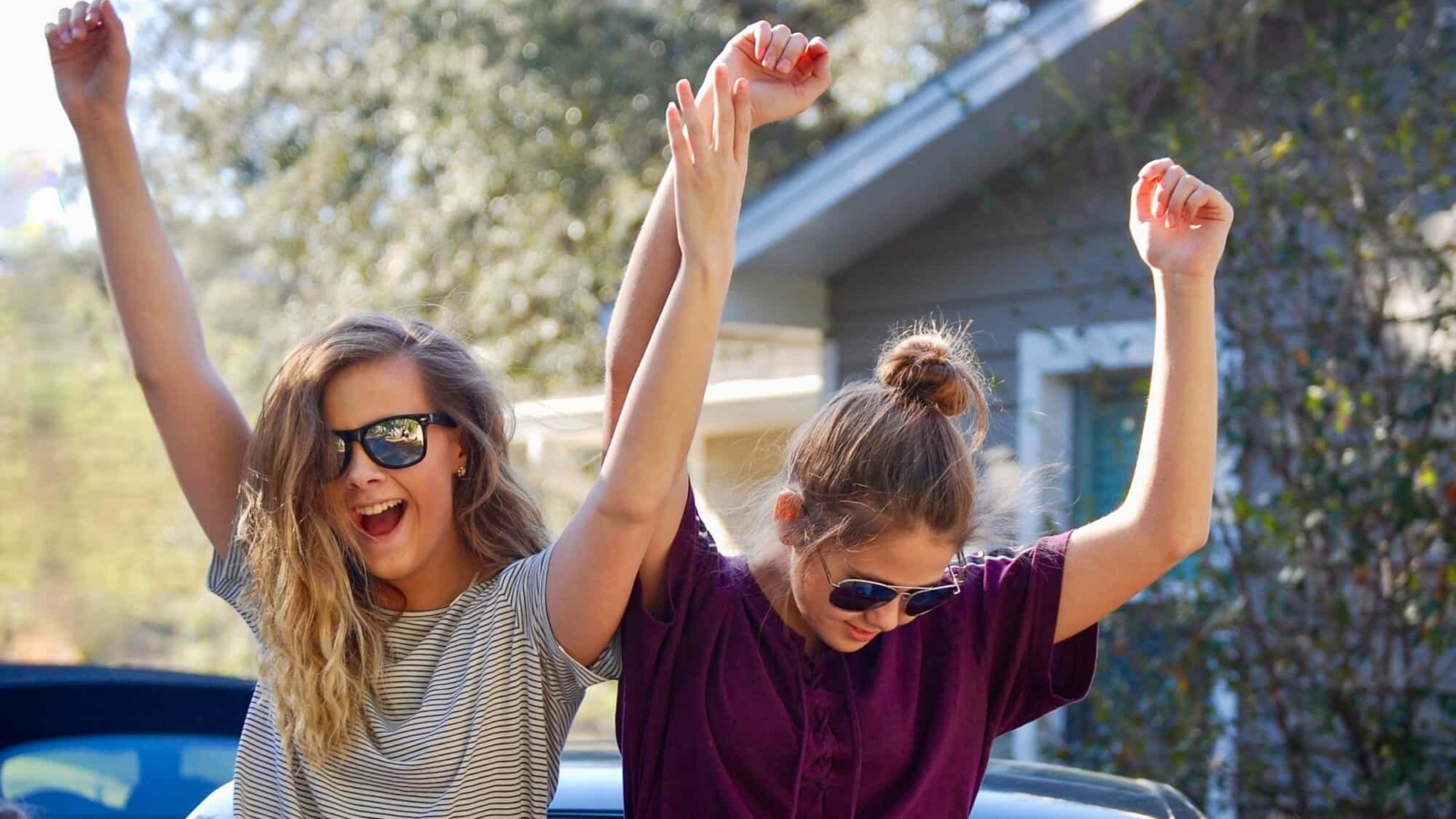 Happy teenage girls dancing outside