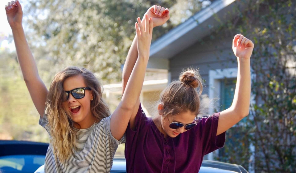 Happy teenage girls dancing outside