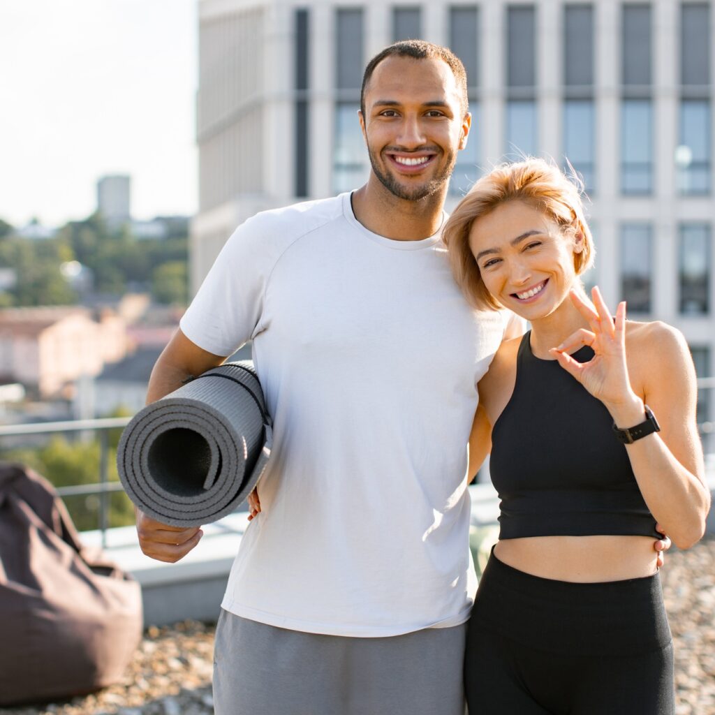 Portrait of happy family doing sports in summer against urban landscape.