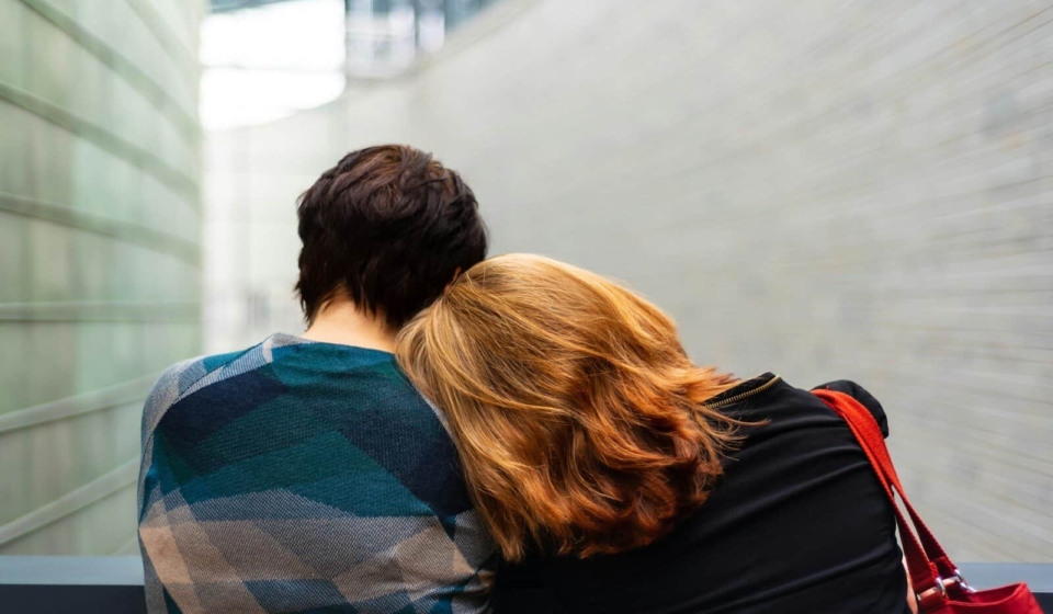 a woman rests her head on another person's shoulder