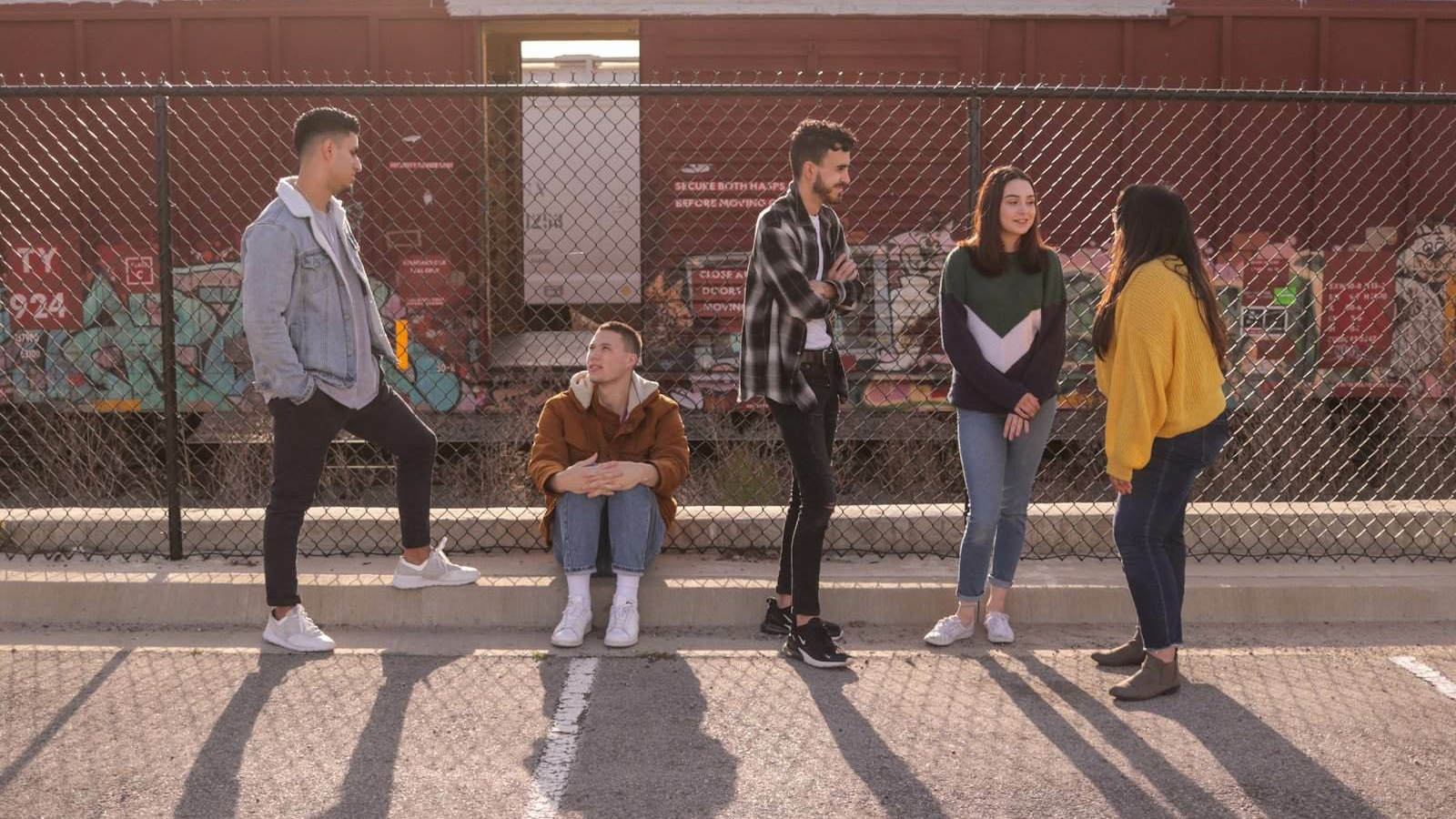 five persons on front of chain link fence