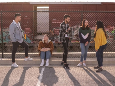 five persons on front of chain link fence