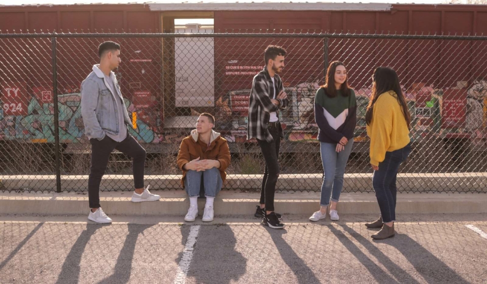 five persons on front of chain link fence